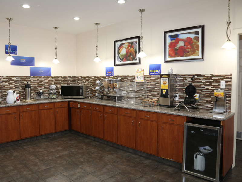 Hotel breakfast area with counters, beverage station, and food service area