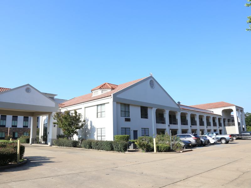 Exterior of Americas Best Value Inn Monroe under a clear blue sky
