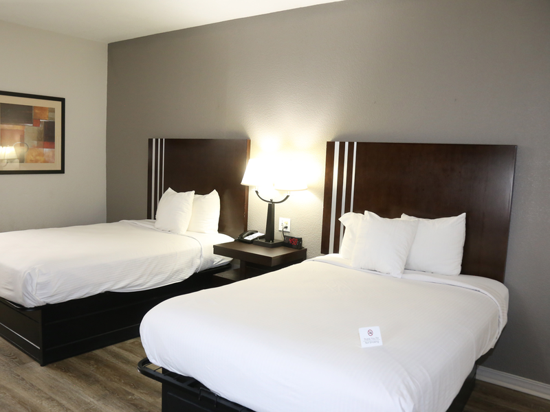 Guest room with two beds and bedside lighting